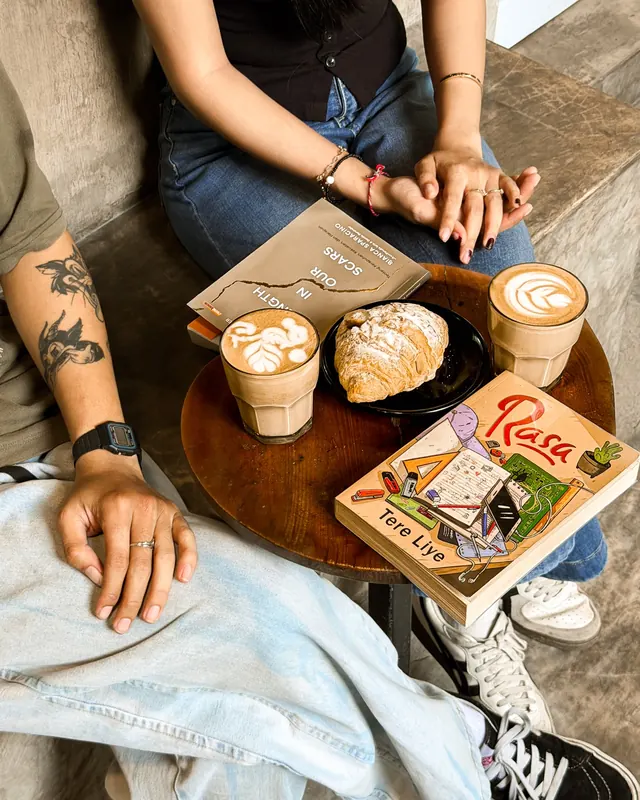 Meja kayu dengan latte dan buku